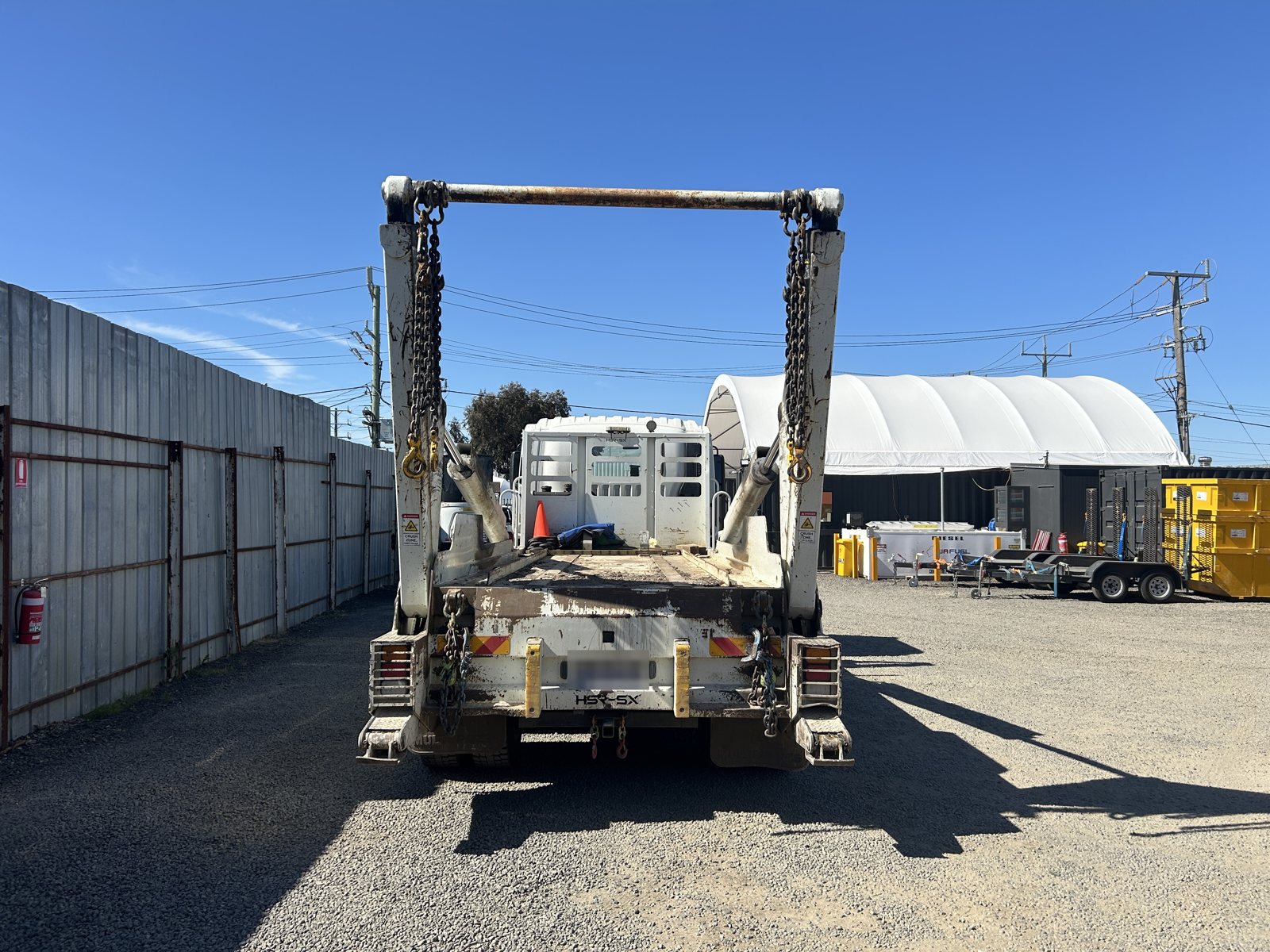 Rear of the big skip truck with lifting arms raised